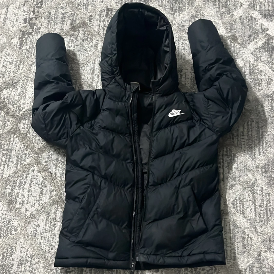 Svart pufferjacka från Nike med huva