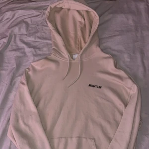 Beige hoodie Axel Arigato - Säljer en beige hoodie från Axel Arigato med svart tryck 'ARIG4TO.14' på bröstet. Riktigt skönt material. Lite små fläckar men inga betydliga