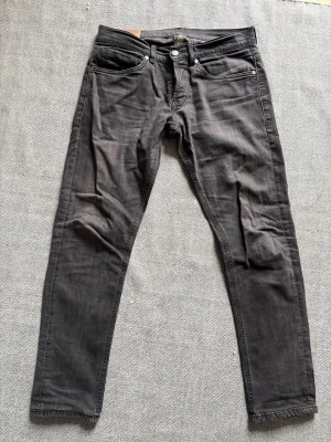 Sköna Dondup Jeans - Snygga svarta jeans med skinny passform och klassisk femficksdesign. Jeansen har en cool detalj med två vita månar tryckta på bakfickan. Materialet är jeans och färgen är mörk svart, perfekt för dig som gillar en stilren look. Dm för frågor🙌👍!