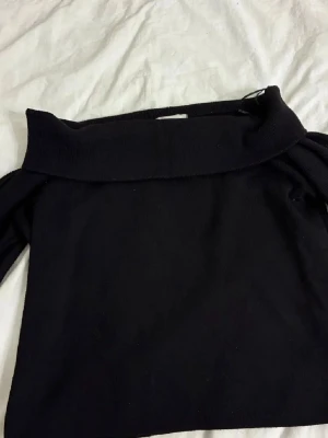 Svart polotröja från H&M - Svart polotröja från H&M i storlek M. Tröjan har en bred krage som kan vikas ner och långa ärmar. Materialet är mjukt och stickat, perfekt för kyliga dagar. Enkel och stilren design som funkar till många olika looks.