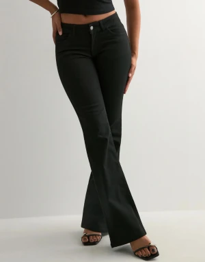 Svarta bootcut jeans med mönster ficka - Snygga svarta jeans med bootcut och mönster ficka . Klassisk femficksmodell med knapp och dragkedja framtill. Jeansen har raka ben som blir vidare nedtill och är tillverkade i ett stretchigt jeansmaterial för skön passform.