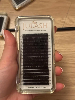 Julash Eyelash Extensions 0.05 D 12mm - Säljer ett paket Julash Golden Edition Eyelash Extensions med svarta fransar i längden 12mm och tjocklek 0.05 D. Fransarna kommer i en transparent och guldfärgad ask, perfekt för dig som vill ha fylliga och snygga fransar. Passar för volymfransar.