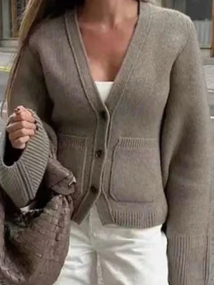 Beige stickad kofta med knappar - Snygg beige stickad kofta med v-ringning och stora ribbade muddar. Koftan har två framfickor och stängs med knappar framtill. Perfekt för dig som gillar en chill och stilren look. Passar till både jeans och kjol.