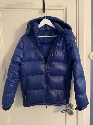 Ralph Lauren glossy pufferjacka - Tja, säljer nu men Ralph lauren jacka då den har blivit för liten. Den är köpt på ralph laurens egna butik i Göteborg. Finns tecken på andvändning men i allmänt mycket bra skick. Storlek XS passar även S, är själv 180 och den är lite liten. Hör av er vid funderingar!