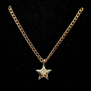 Stiligt halsband med sjärna  - Stiligt halsband med sjärna och zirconia . Stjärna  14K guldpläterad,  1,8cm hög. Kedjetjocklek-3mm 