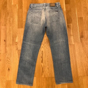 Nudie jeans Big Bengt - Säljer ett fett par Nudie jeans i modellen big Bengt, som inte tillverkas längre. Står att storleken är 30/34 men passar som 30/30.                                                                                     Längd 99cm                                       Midja 40cm                             Benöppning 18,5                                           De är i fint skick. Hör av dig vid intresse eller frågor