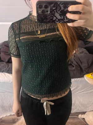 Mörkgrön spetsblus med kort ärm -  mörkgrön blus i spets från Zara!perfekt till lite festligare tillfällen! storlek M men mer som en S.