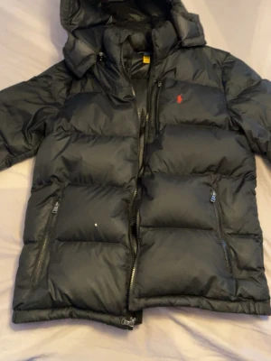 Svart dunjacka Polo Ralph Lauren - Säljer min Ralph Lauren dunjacka. Den är perfekt nu till vintern, de är ett litet hål på höger fickan men de åker inte ut nått dun. De saknas också en lapp på insidan som jag har lyckats fått bort men inget som syns. Vilket ni kan se på dom sista bilderna.
