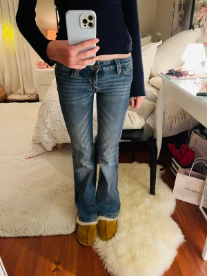 Blå bootcut jeans från Cheap Monday - Säljer ett par snygga blå jeans från Cheap Monday med bootcut-passform. Jeansen har låg midja och är tillverkade i mjukt denim med lätt slitning framtill. Säljer dem då de är för korta