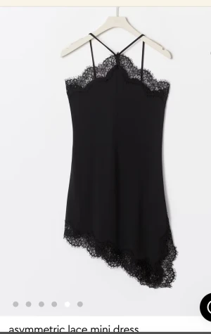 Svart spetsklänning med asymmetrisk kant - Supersnygg svart kort klänning med tunna axelband och spetsdetaljer längs halsringning och nederkant. Asymmetrisk fåll ger en unik look. Perfekt för dig som gillar trendiga och eleganta plagg med en twist. Materialet känns lätt och följsamt. Original pris 499 kronor