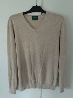 Alan Paine cashmere blandnings tröja - Otroligt populär och snygg beige stickad Alan Paine tröja av högsta kvalite och storlek 48 (m) säljes. Kashmir och bomull som material! I princip helt ny då skicket är utmärkt och inga hål eller fläckar! Tveka inte vid minsta fråga eller fundering och pris ej hugget i sten😊