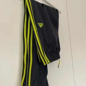 Svarta Adidas byxor med neonränder - Svarta adidas byxor, strl US/L