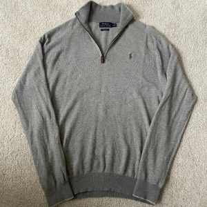 Grå half zip tröja Polo Ralph Lauren | M - Snygg grå långärmad tröja från Polo Ralph Lauren i mjuk pima bomull. Klassisk modell med half zip och broderad logga på bröstet. Tröjan har en liten vit fläck men påverkar inte helheten!