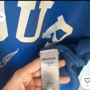 Blå t-shirt från Zadig & Voltaire XS - Snygg blå t-shirt från Zadig & Voltaire i bomull med vit text 'AMOUR' och ett litet vingmotiv framtill. Klassisk rund hals och korta ärmar, perfekt för dig som gillar coola tryck och fransk vibe. ( mina bilder )