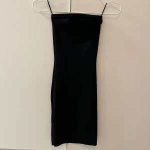 Svart tight finstikad klänning - En svart, tight och finstickad kortklänning. Klänningen är ärmlös och har en minimalistisk design som sitter figurnära. Perfekt för dig som gillar en enkel men snygg look. Klänningen är stretchig. Aldrig använd💋  