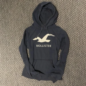 Hollister hoodie - Säljer nu denna snygga Hollister hoodie i dammodell! Stilrent tryck och snygg passform😁 Säljs inte längre i butik och är därav sällsynt🙌 Storleken är S men passar XS. Skriv vid funderingar 📲