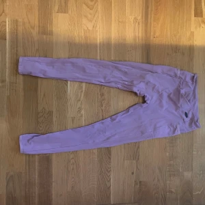 Ljuslila leggings med hög midja - Säljer ett par ljuslila leggings med hög midja. De är tighta och har en mjuk, stretchig känsla som passar perfekt till träning eller chill. Snygg färg som sticker ut och sitter skönt på kroppen.