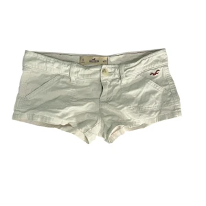 Lågmidjade shorts från Hollister - Lågmidjade vita shorts från Hollister. De har två fickor fram, två bakfickor och en liten broderad logga framtill. Gjorda i mjuk bomull, perfekta för varma dagar. Stängs med knapp och dragkedja 
