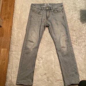 Grå raka jeans från Kappahl W30 L32 - Snygga grå jeans från Kappahl i klassisk femficksmodell. Jeansen har raka ben och normal passform, med diskret tvättad look och silverfärgad knapp. Perfekta till en avslappnad stil och funkar året runt.