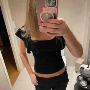 Svart topp med volangärmar - Säljer en svart topp med fyrkantig ringning och korta volangärmar. Strl 158/164 men passar som xs och är i jätte fint skick🩷