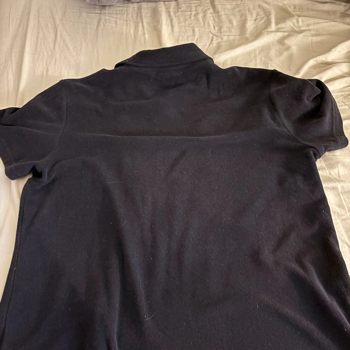 Svart piké med broderad detalj - 1