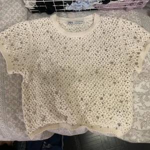 Vit topp med pärlor Zara - Säljer en vit ihålig tröja med pärlor från Zara. Säljer då jag aldrig använder den. Tröjan är liten till storleken även fast det är L!! Super fin och helt orörd!!🩷🩷