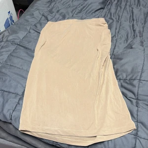 Beige kjol från Vila, storlek S - Enkel och stilren beige kjol från Vila i mjukt och lätt material. Kjolen har rak passform och resår i midjan för extra komfort. Har aldrig använt den och pris lappen sitter fortfarande kvar