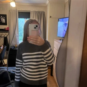 Randig grå och vit stickad tröja - Mysig stickad tröja i grått och vitt med breda horisontella ränder. Perfekt för kyliga dagar och enkel att matcha med jeans eller kjol. Kommer ingeborg vart den är ifrån då jag klippt bort etiketten för att den kliat. Använd max 3ggr