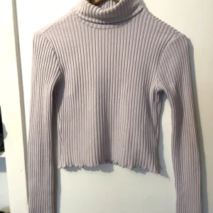 Polotröja - Säljer en superfin ljus lila ribbad polotröja som är perfekt för höst och vinter. Tröjan är croppad och använd fåtal gånger💜❄️
