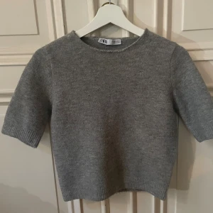 Grå stickad tröja med korta armar  - Säljer min gråa stickad tröja från Zara med kort ärm och rund halsringning. Köp nu jag postar snabbt!!💓💓