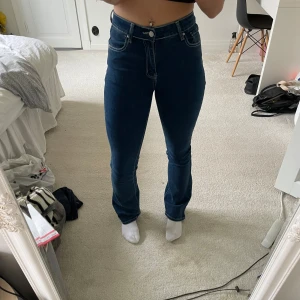 Mörkblå bootcut jeans  - Snygga mörkblå jeans från Shein i bootcut-modell med hög midja. Klassisk femficksdesign med en extra ficka med knapp bak. Jeansen har kontrastsömmar och är tillverkade i stretchigt denim för skön passform.