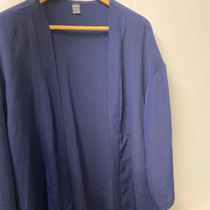 Blå overshirt  - Snygg blå overshirt  med avslappnad passform och långärmade ärmar. Materialet är lätt och har en diskret ribbad struktur. 