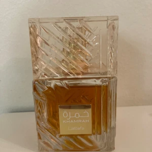 Lattafa Khamrah  - Khamrah från Lattafa är en elegant parfym i en snygg flaska med unik design. Perfekt för dig som vill sticka ut och ge din stil en extra touch. Passar dig som gillar trendiga och moderna dofter. 95/100ml ~