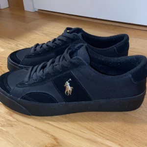 Polo Ralph Lauren sneakers  - Svarta SAYER CANVAS & SUEDE SNEAKERS. Perfekt för vardagen. Använda ungefär 5 gånger. Storlek 40. Boxen saknas dock. Om de något du undrar över kan du meddela mig.