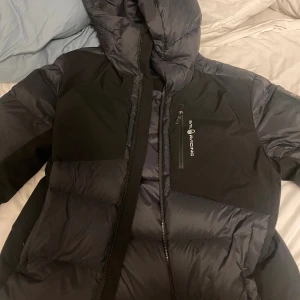 Sail racing SR down jacket  - Väldigt varm och tjock jacka till vinter, nu när de börjar bli kallt. Väldigt skönt material, vattentålig. Kommer inte behöva ha dubbla tröjor på dig med denna jackan håller dig varmare än bastu. Kan tänkas gå ner i pris men inte mycket då jag endast använt den fåtal gånger. Skick nästan helt ny. Köpt för 3100
