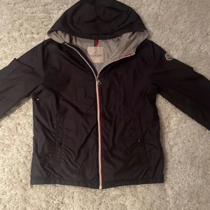 Moncler windbreaker 14y - Den är storlek 14y vilket passar typ 168-172cm. Jag säljer den för 2299kr men pris kan diskuteras,🔥🏆 skick 9,5/10 inget defekt eller repa vad jag har sett 
