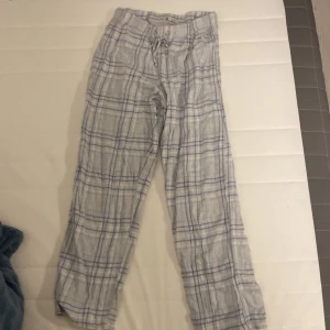 Rutig mjukisbyxa med snörning - Mysiga mjukisbyxor från Cubus i storlek 158/164. Byxorna är ljusgrå med blått rutmönster och har en bekväm snörning i midjan. Perfekta för chill hemma eller när du vill vara extra comfy. Materialet känns skönt mot huden.