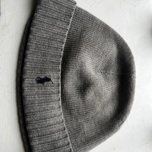 Grå stickad mössa från Polo Ralph Lauren - Snygg grå mössa från Polo Ralph Lauren med ribbad kant och klassisk broderad logga framtill. Stickad i mjukt material som håller dig varm under kyliga dagar. Priset kan diskuteras!