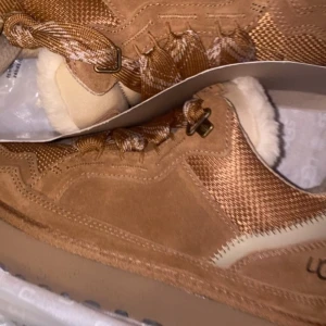 UGG lowmel - Säljer ett par snygga skor från UGG med snörning och mjukt foder på insidan. Skorna har en robust platt sula, detaljer i mocka och textil samt rund tå. Perfekta för kalla dagar och ger en riktigt cozy vibe. knappt använda, pris kan diskuteras. 