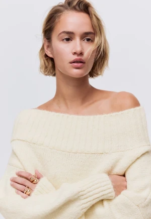 Offshoulder stickad tröja i ljus beige - Supermysig offshoulder stickad tröja i ljus beige med bred ribbad kant upptill och vid ärmslut. Tröjan har en loose passform och är perfekt för lager-på-lager. Snygg att styla med både jeans och kjol. Knappast använd storlek xs men passar s.