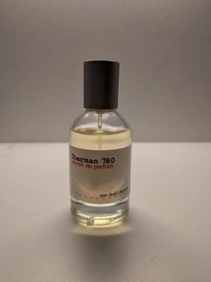 Sherman 78.0 extrait de parfum - Denna doft öppnar med en varm och kryddig blandning av äpple, kanel och rökiga inslag. I hjärtat finner du rökig tobak, söt vanilj och jordig mossa. Basen är en komplex och djup kombination av bourbonvanilj, Orcanox™, lakrits, Iso E Super och aromatisk salvia, som tillsammans skapar ett sofistikerat och långvarigt slut.  Toppnoter: Äpple, Kanel, Rök  Mellannoter: Tobak, Vanilj, Mossa  Basnoter: Bourbonvanilj, Orcanox™, Lakrits, Iso E Super, Muskatellsalvia Koncentration: 25,0 %   Slutsåld