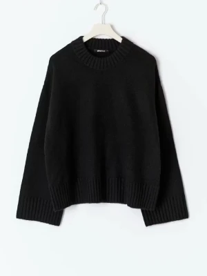 Svart stickad tröja från Gina Tricot - Mysig svart stickad tröja från Gina Tricot med bred ribbad kant vid hals, ärmslut och nederkant. Tröjan har en loose passform och är långärmad, perfekt för kyliga dagar. Enkel och stilren design som funkar till allt.