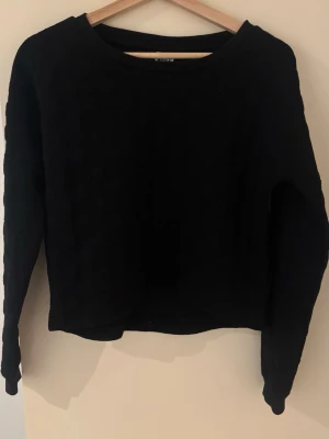 Svart stickad tröja från Vero Moda - Mysig svart stickad tröja från Vero Moda i storlek XS. Tröjan har rund halsringning och långa ärmar, perfekt för kyligare dagar. Enkel och stilren design som passar till det mesta.