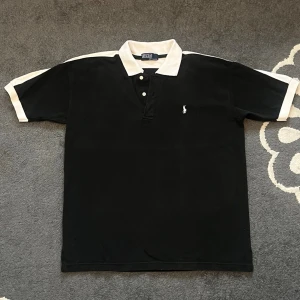 Ralph Lauren svart pikétröja med vita detaljer - 100% Bomull  👕 Storlek: Motsvarar ca XL 📦 Skickas snabbt             Mått: Bröstvidd: 58 cm Längd: 71 cm