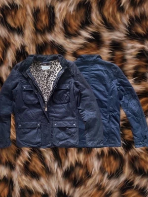 Mörkblå parkajacka med leopardfoder - Säljer denna sällsynta field jacket från Ralph Lauren Denim & Supply. Klädserien lades ner 2016 vilket gör detta plagg svårt att få tag på och eftertraktat. Storlek: M på etikett, passar bättre slim S Mått: Se sista bild Färg: Svart, Leopardmönster Jackan har många fina detaljer bland annat fickorna, kragen och framförallt den vackra leopardmönstrade pälsen. OBS! Lägg märke till den lilla lagningen på kragen som knappast syns på närbild och framförallt inte när den är på.