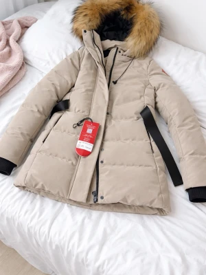 Beige dunjacka från Canada Goose - Säljer en Canada Goose vinterjacka i mycket fint skick. Jackan är aldrig använd och lappar sitter fortfarande kvar. Klassisk och tidlös modell i beige färg med äkta päls runt huvan.  Jackan är varm, vindtät och perfekt för kalla vinterdagar. Midjan är lätt insvängd vilket ger en fin passform.Pris kan diskuteras vid snabb affär.                                                                       • Märke: Canada Goose • Storlek: S • Skick: Nyskick / oanvänd • Färg: Beige • Päls: Äkta