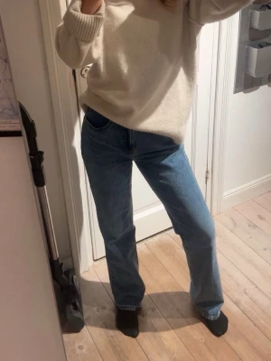 Vero Moda blå raka jeans - Klassiska  jeans i mellanblå tvätt med rak passform och hög midja. Jeansen har fem fickor, knappgylf och är tillverkade i robust denim av bomull. Perfekta för dig som gillar en tidlös och avslappnad look.