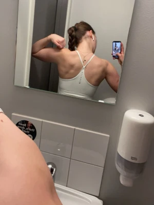 Vit träningstopp från relode  - Supersnygg träningstopp från Relode med inbyggd bh och skön passform som definierar ryggen