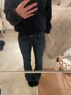 Vintage Levis mörkblå bootcut jeans - 🫶🏻Storlek: Jag är 175 och de sitter bra i längden. De har större lår. Skulle säga M🫶🏻🩷Säljer ett par Vintage Levis Bootcut jeans fint skick och i mörkblå tvätt. Klassisk femficksmodell med snygga kontrastsömmar och låg midja. Jeansen har bootcut-ben och är tillverkade i slitstarkt denimtyg av bomull. Perfekta för dig som gillar en tidlös och avslappnad look.💕 🤍Fått de som använda🤍