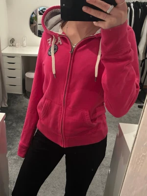 Rosa hoodie  - Rosa Abercrombie and fitch hoodie med dragkedja, storleken är i L en jag är en S tjej så den är väldigt liten i storlek, knappt använd💕